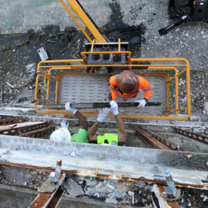 Construction workers on a suspended platform collaborating on a building site, emphasizing teamwork in the construction industry.