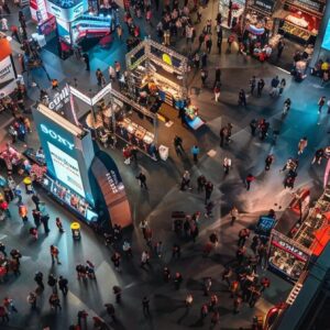 Aerial view of a bustling construction trade show with numerous exhibitors, attendees interacting, and vibrant displays showcasing construction marketing strategies.