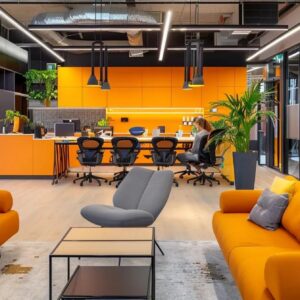 Modern office space featuring vibrant orange accents, comfortable seating, and a collaborative work area, emphasizing a dynamic environment for email marketing strategies in the construction industry.