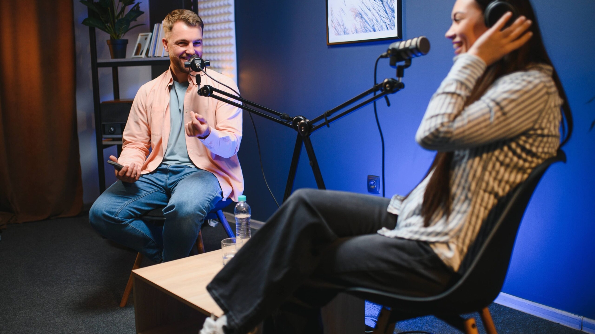 Podcast hosts engaging in conversation, discussing architecture and business topics, with microphones and a modern studio setup.