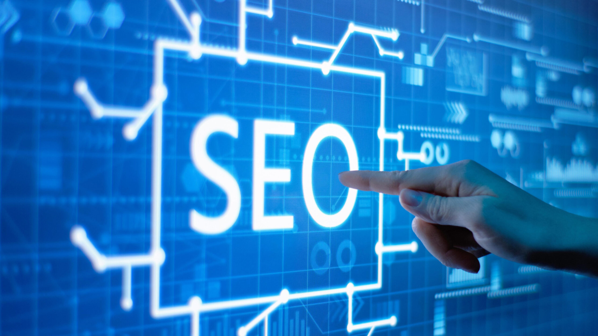 Hand pointing at illuminated "SEO" text on a digital screen with circuit-like graphics, symbolizing the integration of traditional SEO and AI search optimization for effective digital marketing strategies.